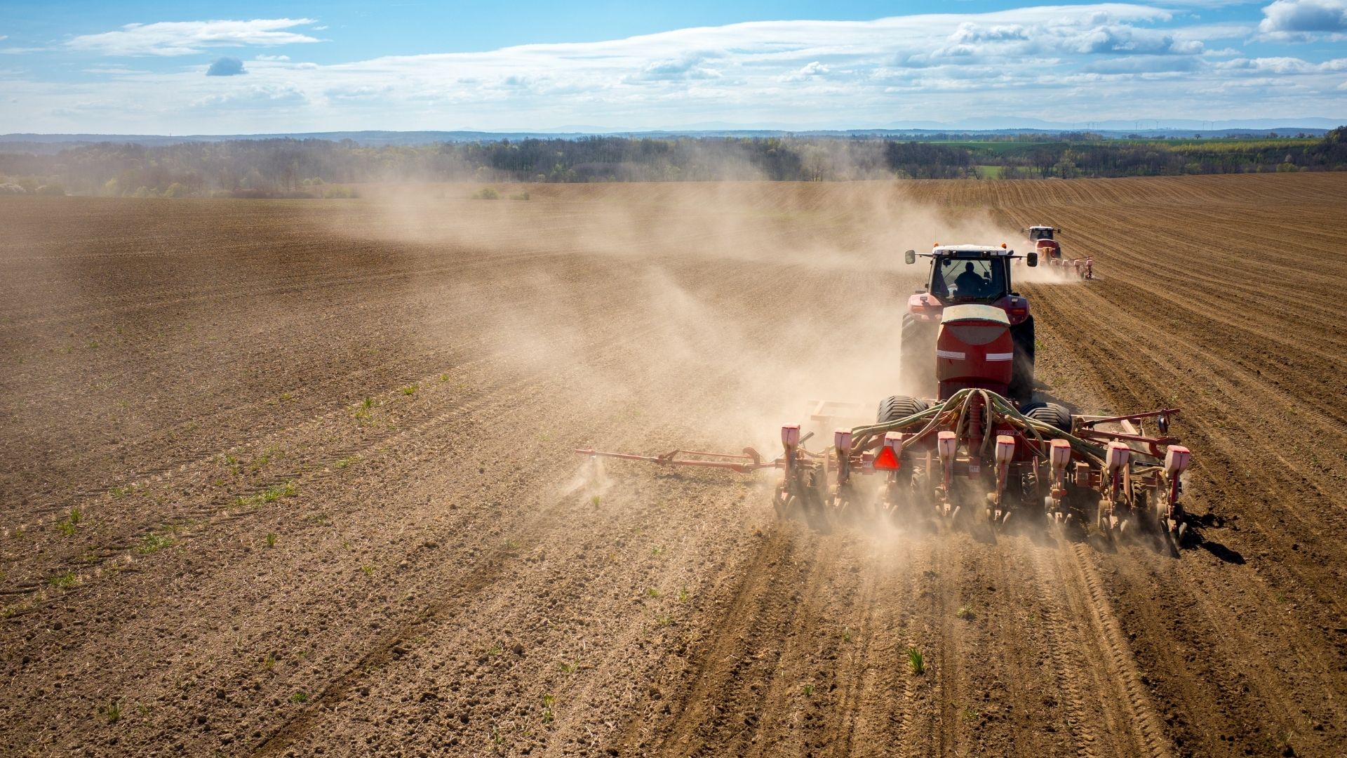Fermieri la lucrările agricole de primăvară cu tractoare și semănători pe câmp
